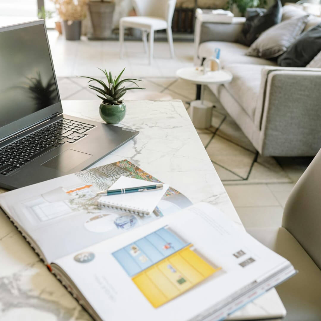 Dolgozóasztal jegyzetekkel és füzettel egy természetes fényű nappaliban – kreatív tér webshop tervezéshez